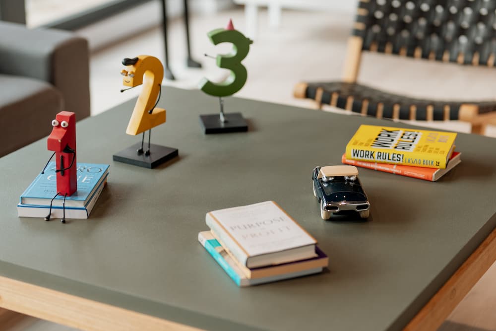 Una mesa de centro con figuras decorativas con forma de los números 1, 2 y 3, así como algunos libros y un pequeño coche de juguete.